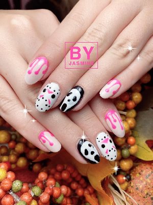Pink almond nails feature neon-pink drips and alternating white-and-black horror-mask faces.