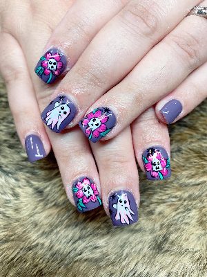 Short square purple nails decorated with cute white ghosts, skull-centered pink flowers, leaves, and small spiders.