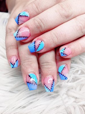 Medium square nails with pink, turquoise, and blue patchwork sections outlined by black painted stitches.