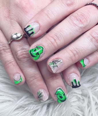 Short square nails with neon green monster faces, black drips, spiderwebs, and green French accents.