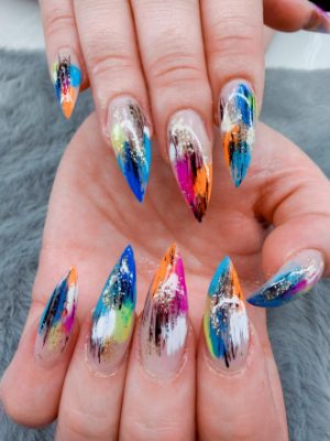 Long stiletto nails with multicolor abstract brushstrokes, black streaks, and glitter accents.