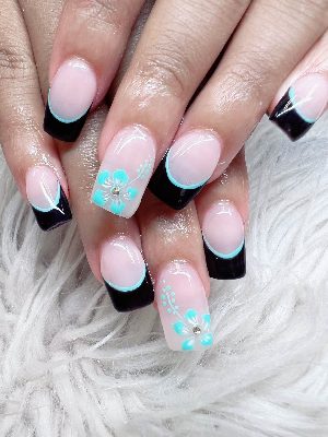 Long square nails with pale pink bases, black French tips outlined in turquoise, and turquoise floral accent nails with rhinestones.
