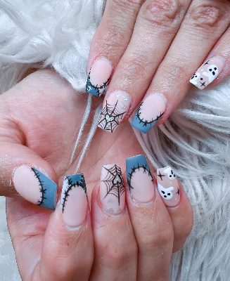 Long square pink nails with blue stitched French tips, black spiderwebs, white ghosts, and small silver glitter hearts.