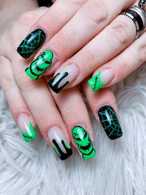 Medium square nails with neon green monster faces, black-and-green drips, spiderwebs, and stitched French tips.