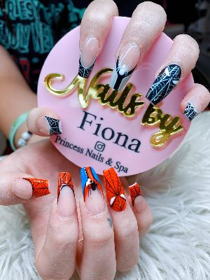 Extra-long coffin nails with red and black spiderweb art, spiders, and comic-inspired mask details.