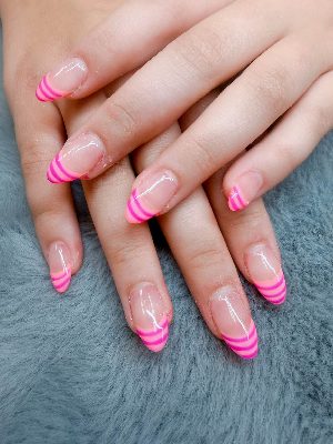 Medium almond nails with a clear nude base and three layered curved French-tip stripes in pale, bright, and deep pink.