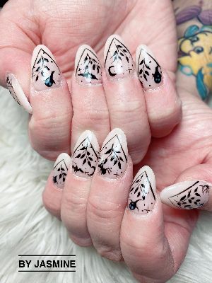 Long almond nails with nude-pink bases, black botanical branches, bats, spiders, a crescent moon, and fine outlined borders.