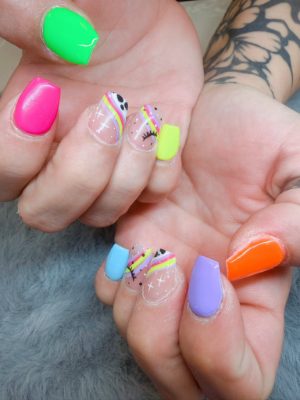 Square nails with neon solid colors, rainbow stripe accents, black dots, and small star details.