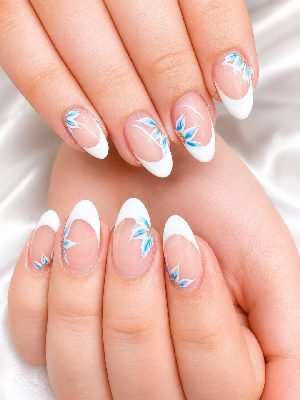 Medium glossy almond nails with a sheer pink base, crisp white French tips, blue-and-white floral petals, and tiny gold centers.