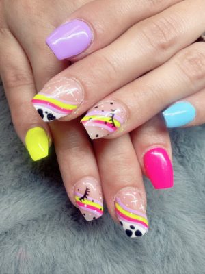 Square nails with neon yellow, pink, blue, and lavender solids plus rainbow waves, black dots, and lash-like linework.