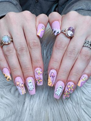 Full view of long pink coffin nails decorated with ghosts, smiling flowers, mushrooms, crescent moons, eyes, stars, and waves.