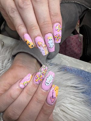 Long pink coffin nails with white ghosts, smiling flowers, mushrooms, crescent moons, eye motifs, stars, and pastel waves.