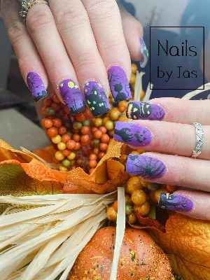 Medium square purple nails with matte Halloween scenes including jack-o'-lanterns, a haunted house, graves, cat, bats, moon, and web.